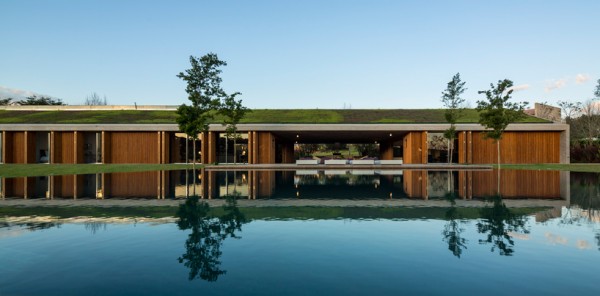 Retractable wooden doors, reflected in pool on main patio. Image via Studio MK27.