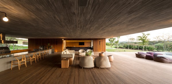 Living room open to the elements under massive concrete roof. Image via Studio MK27.