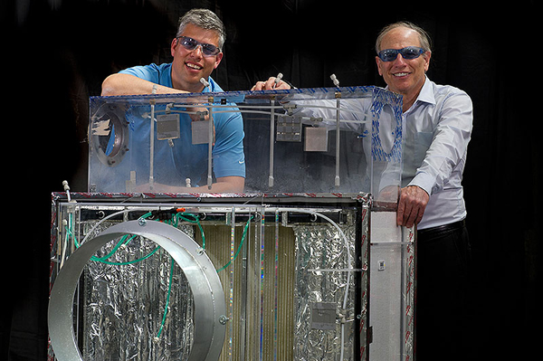 Eric Kozubal, left, and Ron Judkoff stand next to a first-generation prototype DEVAP air conditioner. The new technology predicts an energy savings of 40% to 80% for light commercial buildings. Jason Woods and Jay Burch, also members of the DEVAP team, are not pictured. (image credit: Dennis Schroeder/NREL)
