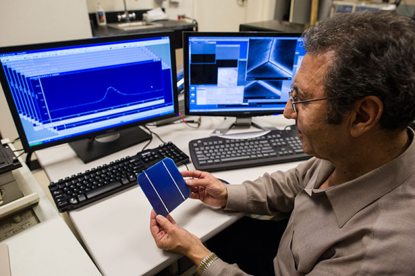 NREL Principal Scientist Mowafak Al-Jassim holds a TetraSun PV cell in the cathodoluminescence lab at NREL. The TetraSun cell combines increased efficiency and low cost, breaking the usual rules for solar cells. (image credit: Dennis Schroeder/NREL)