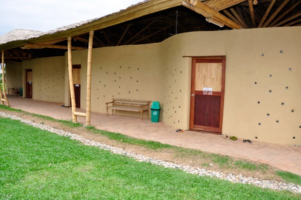 Embedded bottles in the adobe walls help draw natural light into the classrooms. Image via Panyaden School.