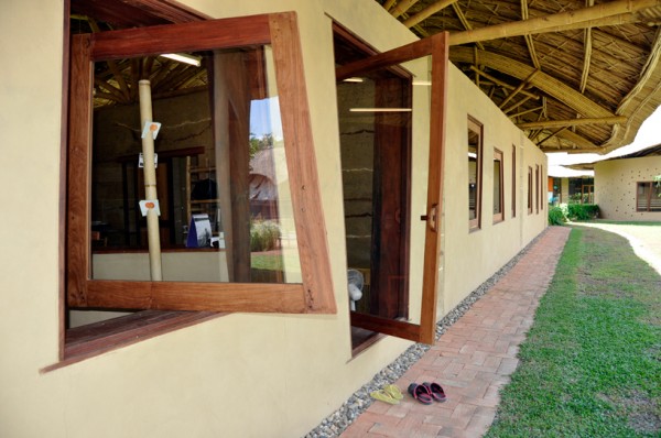 Glass windows and doors open on a pivot to allow easy ventilation in the tropical climate. Image via Panyaden School.