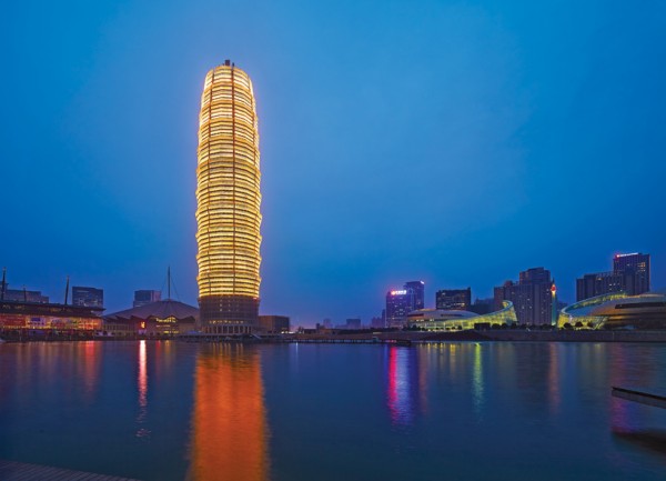 The recently completed Greenland Tower in Zhengzhou, China, shines brightly at night with its reflective window panels. Image via SOM.