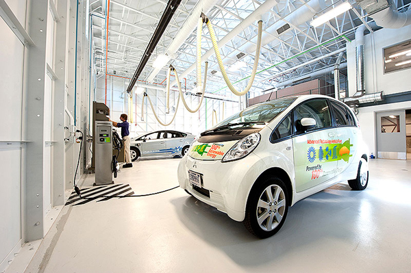 NREL scientist Michael Kuss of the NREL Electric Vehicle Grid Integration Team reads data from test electric vehicles at the Vehicle Testing and Integration Facility (VTIF). (image credit: Dennis Schroeder/NREL)