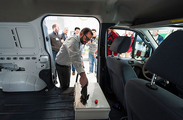 NREL Vehicle Systems Engineer Mike Simpson connects a direct current (DC) battery from an electric vehicle to a grid charging system that supplements the grid with stored electricity from the vehicle. (image credit: Dennis Schroeder/NREL)