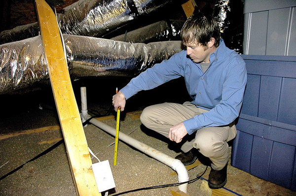 United Energy Conservation Coordinator Seth Rosser measures insulation as part of an energy audit at a member's home. (image via USDAgov/Flickr)